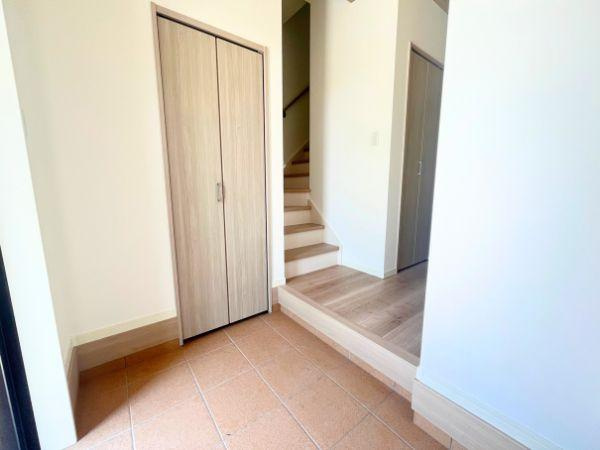 AG-HOUSE　光吉　A棟の玄関|落ち着いたタイル調の床が温かみを感じさせる玄関。シューズクローゼットを備えており、家族全員の靴や外出用品もすっきり収納できます。階段やホールへの動線もスムーズで、毎日の出入りが快適に行える設計です！
