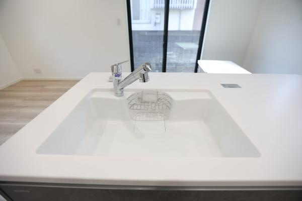 AG-HOUSE　光吉　A棟のキッチン|ゆとりのある広さで、大きな鍋やフライパンも洗いやすいワイドシンク。水ハネを抑えた設計と滑らかな一体型カウンターで、見た目もすっきり清潔感たっぷり。シャワー水栓付きで後片付けもラクラクです♪