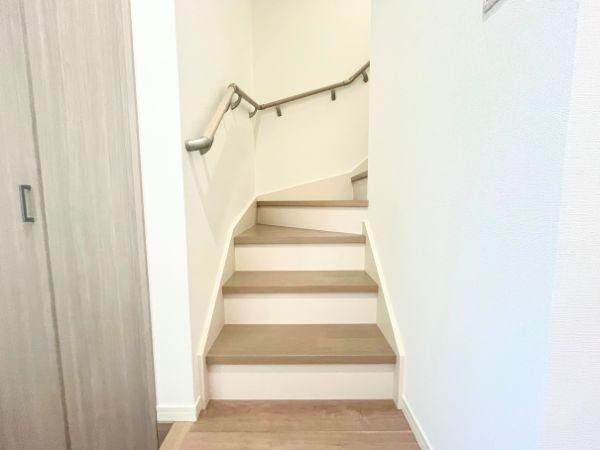 AG-HOUSE　光吉　A棟の内装|やさしい色合いのフローリングと一体感のある階段は、手すり付きで安全性にも配慮。お子さまやご高齢の方にも安心してご利用いただけます。壁側にゆるやかに沿ったデザインで、動線もスムーズに確保されています♪