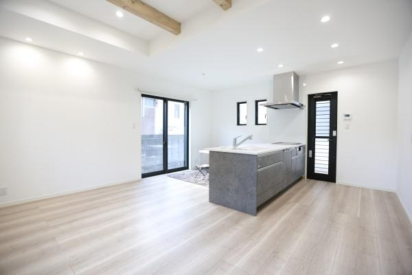 AG-HOUSE　光吉　A棟の居間・リビング|勾配天井に映える木目の梁が空間に温もりを添えるリビング。大きな窓から光がたっぷり差し込み、キッチンとのつながりも感じられる、家族の会話が自然と広がる心地よい空間です！