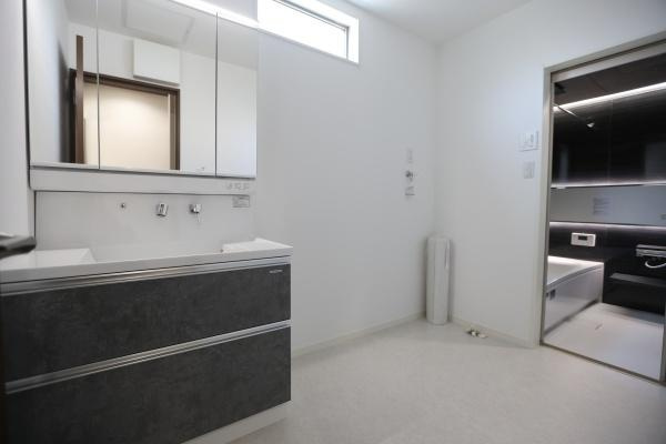 AG-HOUSE　光吉　B棟の独立洗面台|採光性の高い窓付きで明るく、清潔感あふれる洗面スペース。三面鏡とたっぷりの引き出し収納で、身支度もスムーズに行えます。洗濯機置き場もゆとりのある設計で、脱衣や家事動線にも配慮された機能的な空間です！