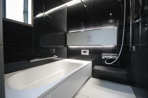 AG-HOUSE　光吉　B棟の浴室|ダークカラーのパネルが落ち着きと高級感を演出するバスルーム。ゆったりとした浴槽で一日の疲れを癒せます。浴室乾燥機や追い焚き機能も備え、快適性と機能性を両立。窓付きで明るく換気もしやすい空間です♪