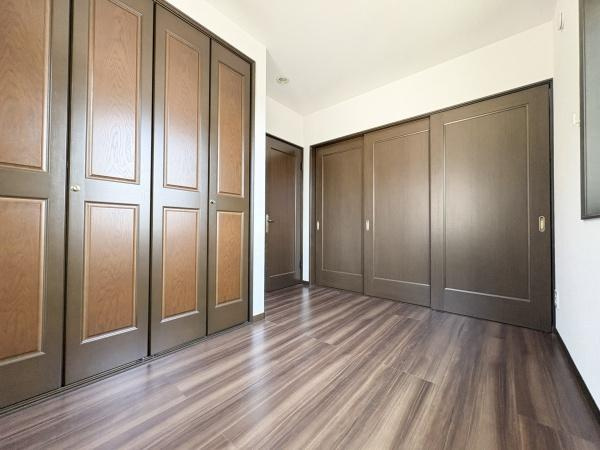 京が丘南4丁目　中古の洋室|木目調のフローリングが室内に落ち着きをもたらしています。収納スペースが豊富で整理整頓に便利です。窓から自然光がしっかりと入る明るい洋室です。壁と扉の色が調和し雰囲気の良い空間が広がっています。