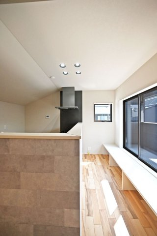 ハッピータウン伊丹瑞穂町6丁目新築一戸建てのキッチン|キッチン前の大きな窓に面した造作カウンター。心地よい陽光を感じながら、ベンチやディスプレイスペースなど多彩に活用できる魅力的な空間です。