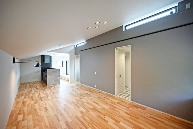 ハッピータウン伊丹瑞穂町6丁目新築一戸建ての居間・リビング|木の素材感と落ち着いたアクセントクロスが美しく調和したLDK。個性的なインテリアにも映える、上質で洗練された空間です。