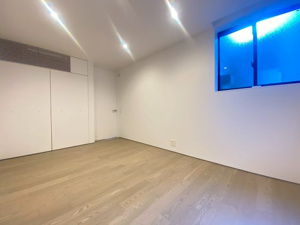 【洋室】 | 柔らかな色味のフローリングが心地よい、開放感あふれるお部屋です。ダウンライトが天井をすっきりと見せ、穏やかな時間を演出。窓からの光が壁に反射し、室内を明るく包み込みます。家具配置も楽しみな一室♪