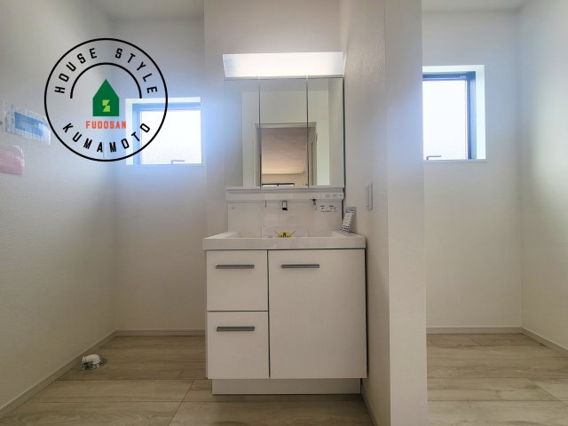 菊池郡大津町第4-1棟（1号棟）　の独立洗面台|毎日使うものだから清潔な空間を保ちたい水回り。洗面にはそんな願いを解消させてくれる収納アイデアが満載です。三面鏡の裏側にはキャビネットが現れ小物から背の高い物まで収納できます。