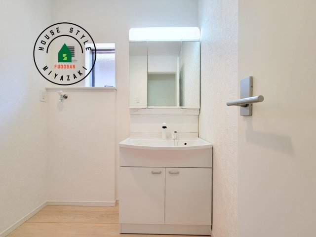 都城市一万城町第2-3棟（2号棟）の独立洗面台|毎日使うものだから清潔な空間を保ちたい水回り。洗面にはそんな願いを解消させてくれる収納アイデアが満載です。三面鏡の裏側にはキャビネットが現れ小物から背の高い物まで収納できます。