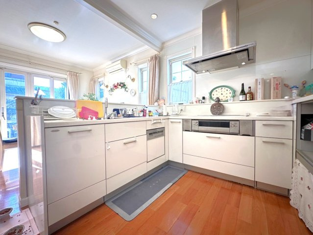 練馬区大泉学園町４丁目　中古一戸建　西武池袋線　大泉学園のキッチン|明るく開放感あふれるL字型キッチン。大きな窓から自然光がたっぷり差し込み、心地よい空間でお料理を楽しめます。広々としたワークトップと豊富な収納で、機能性とデザイン性を兼ね備えた使いやすいキッチンです。