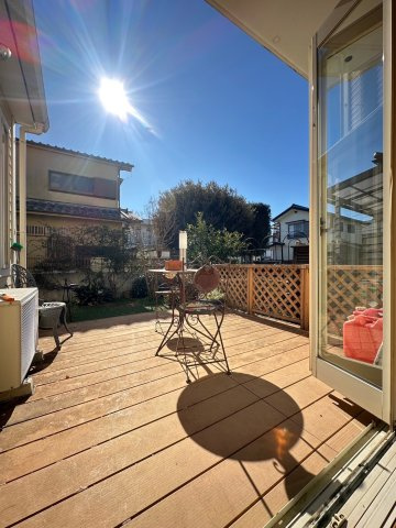 練馬区大泉学園町４丁目　中古一戸建　西武池袋線　大泉学園のバルコニー|リビングと一体感のある開放的なウッドデッキ。大きな窓を開ければ、心地よい風と陽光が差し込み、お庭の緑を眺めながら、家族や友人とカフェタイムやアウトドアリビングを楽しめる特別な空間です。