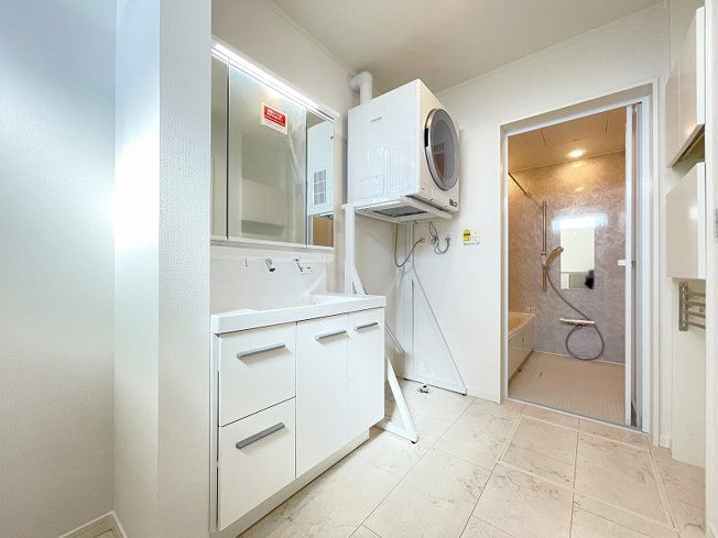 【その他】 | トラストステージ×カラーズ　練馬区西大泉2丁目9期　全26棟 | 【ご成約済み／洗面脱衣室】
バックガードと洗面ボウルが一体型となった900Wの大型洗面化粧台、低コスト＆短時間で乾燥が完了するガス衣類乾燥機「乾太くん」が備わり快適な暮らしが叶います。