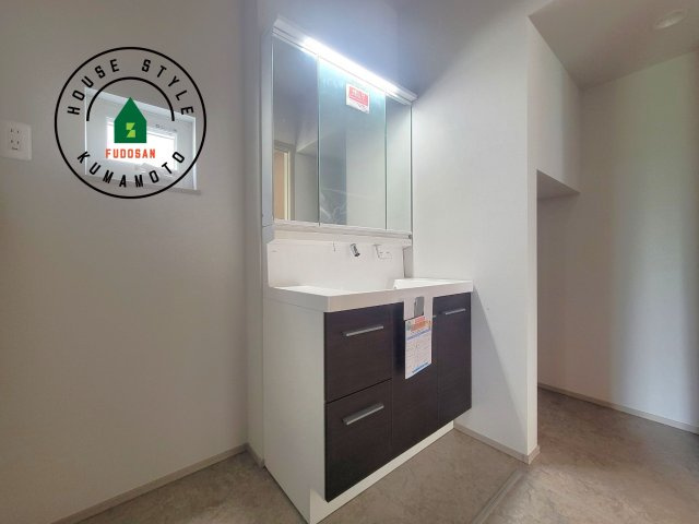 上益城郡御船町陣第1-1棟（1号棟）の独立洗面台|毎日使うものだから清潔な空間を保ちたい水回り。洗面にはそんな願いを解消させてくれる収納アイデアが満載です。三面鏡の裏側にはキャビネットが現れ小物から背の高い物まで収納できます。