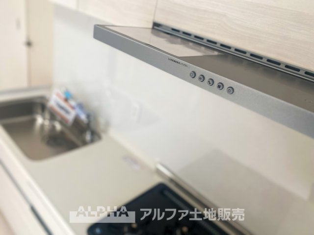 立川羽衣町住宅2号棟のキッチン|武骨なまでに磨きこまれたステンテクスチャーはコンテンポラリー・デザイン。ダウンライトがフードを照らし煌めきの瀟洒なキッチンを演出する。清潔感のあるデザインが、キッチン全体の雰囲気に調和します。