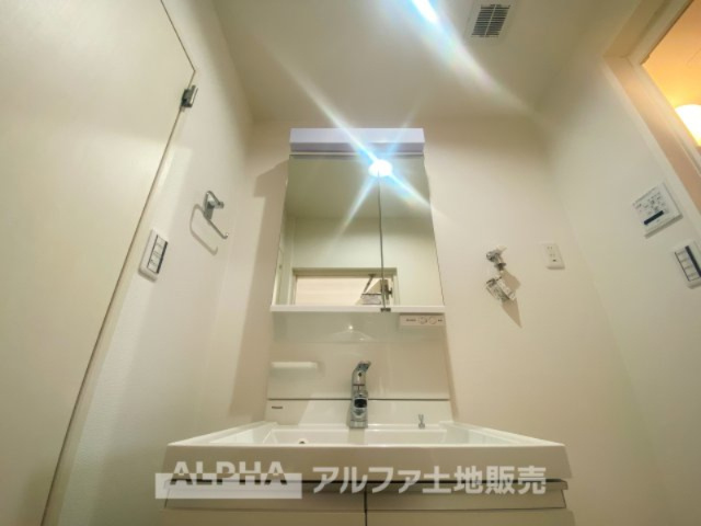 立川羽衣町住宅2号棟の独立洗面台|身支度には、歯ブラシ・コップ・化粧品類など様々な小物を使用するので散らかってしまいがち。鏡の裏収納でたっぷり収納して生活感を隠し、スタイリッシュな空間に。