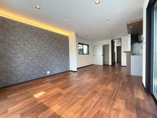 【居間・リビング】 | ◆ウッドデッキのある新築戸建◆ | 約18.7帖のLDK：アクセントクロスの上部には間接照明があり、落ち着いた雰囲気