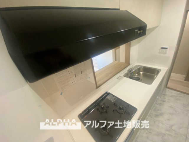 ライオンズマンション高幡不動第二のキッチン|武骨なまでに磨きこまれたステンテクスチャーはコンテンポラリー・デザイン。ダウンライトがフードを照らし煌めきの瀟洒なキッチンを演出する。