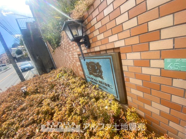 ライオンズマンション高幡不動第二の外観|レンガ調の外壁と植栽が調和するエントランス。陽射しに映える館銘板が、温かみのある住まいを演出します。落ち着いた街並みに佇む、穏やかな暮らしが叶う住環境です。