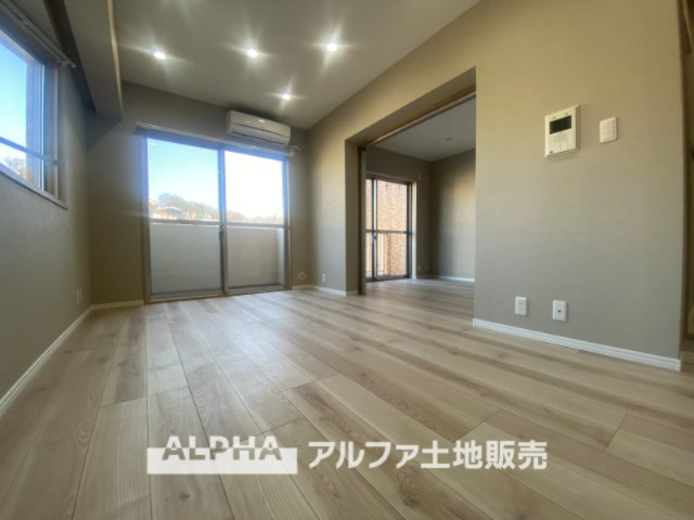 ライオンズマンション高幡不動第二の居間・リビング|リビングルームのドアを開くと、窓から飛び込むのは緑と光の風光明媚な景色。僕の目に映るは、ここで家族と会話をワイワイガヤガヤ楽しんでいる様子。