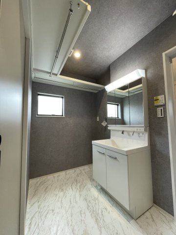 古江東町　新築一戸建ての洗面所|三面鏡付き洗面化粧台の洗面室は、花粉時期や梅雨時期にも重宝する、室内干し用のハンガーパイプ付きです