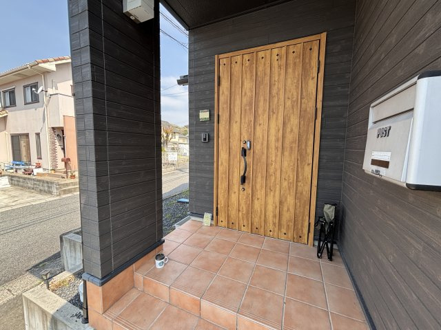 津山市西吉田　平屋中古住宅２LDKの玄関|テラコッタ風タイルと木調ドアがおしゃれな玄関