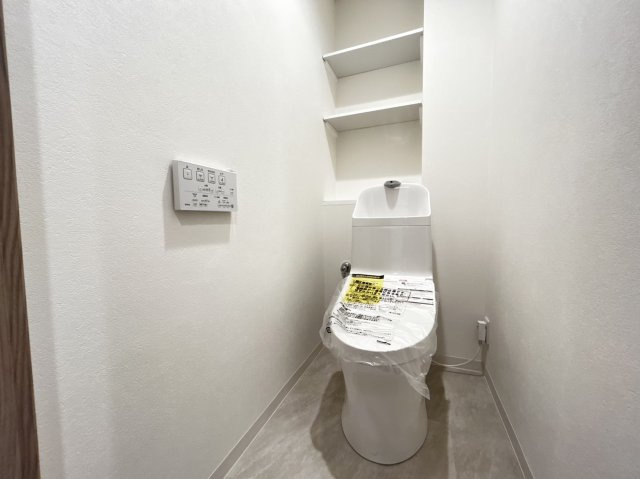 ライオンズマンション六甲口のトイレ|温水洗浄便座で後ろの収納スペースには消耗品を置いて活用できます。
