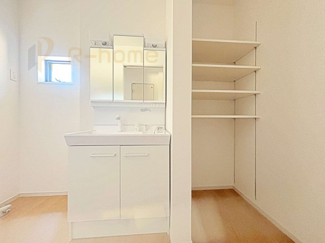 水戸市見川21期　新築戸建て　2号棟の洗面所|清潔感溢れる洗面台は嬉しい三面鏡。タオルや衣類の収納に便利な可動棚付き！