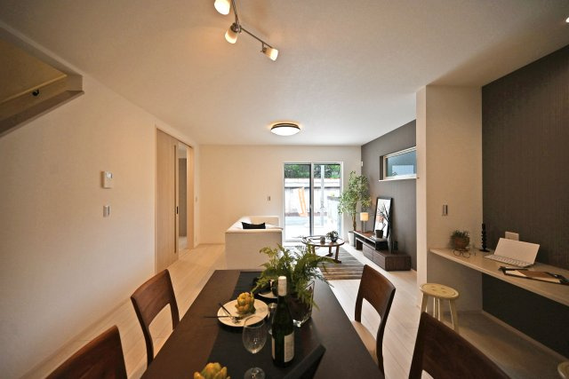 尼崎市東園田町7丁目新築一戸建て│2LDK+2S│並列駐車2台可の居間・リビング|キッチン前からLDKを正面に撮影した内観写真です。奥右側にテレビボードを置く配置関係で、対面式キッチンなので調理中もご家族の顔が見渡せます。