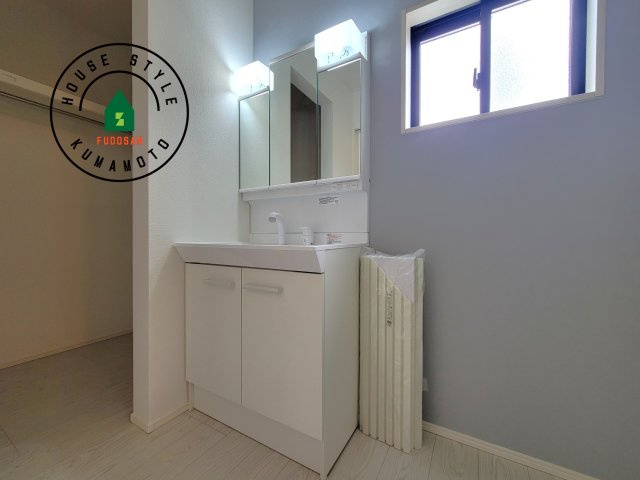 合志市御代志第12-1棟（8号棟）　の独立洗面台|毎日使うものだから清潔な空間を保ちたい水回り。洗面にはそんな願いを解消させてくれる収納アイデアが満載です。三面鏡の裏側にはキャビネットが現れ小物から背の高い物まで収納できます。