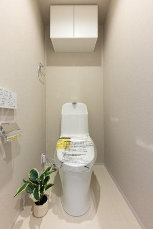 ライオンズマンション茅ヶ崎中央公園のトイレ|掃除用具等の収納に便利な吊戸棚を設置。温水洗浄機能付きの便座で快適で清潔な使用感を得られるトイレ