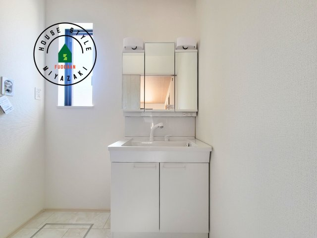 宮崎市熊野2期-4棟（C号棟）の独立洗面台|毎日使うものだから清潔な空間を保ちたい水回り。洗面にはそんな願いを解消させてくれる収納アイデアが満載です。三面鏡の裏側にはキャビネットが現れ小物から背の高い物まで収納できます。