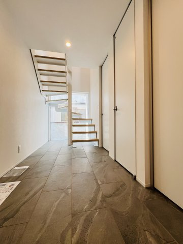 「海と暮らす、家族の未来。」SHONAN STYLEな家～辻堂6丁目の玄関|玄関・廊下には高級感＆デザイン性に優れたタイルを採用。中央にはスケルトン階段