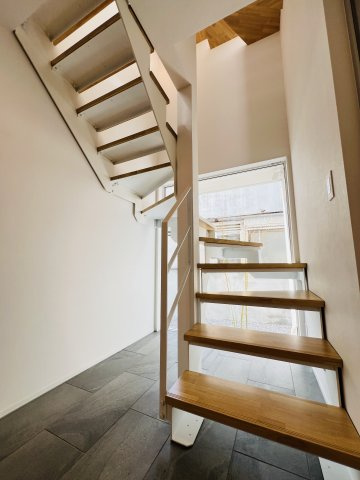 「海と暮らす、家族の未来。」SHONAN STYLEな家～辻堂6丁目の玄関|デザイン性に優れたスケルトン階段。大きな窓からは庭が見えます