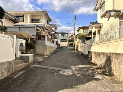 【前面道路含む現地写真】 | 陽だまりの丘で育むあたたかな家族時間　熊本県東区戸島本町 | 前面の接道は坂道になっています。