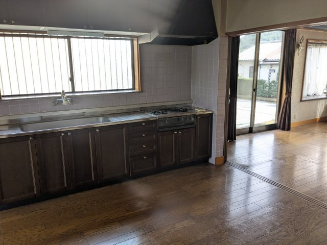 中古戸建　藤塚町のキッチン|シックな木目調のデザインキッチン。広々とした調理スペースと、自然光あふれる開放的な空間が自慢です。