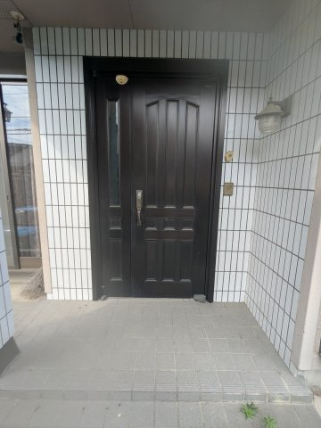 中古戸建　藤塚町の玄関|重厚感あるドアと清潔感あふれるタイル貼りが印象的。落ち着きと風格で住まいの顔を彩る玄関ポーチです。
