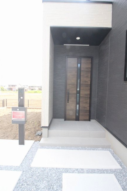 グラファーレ　小山市雨ケ谷新田　2号棟の玄関|モダンな木目調ドアが目を惹く玄関まわり。屋根付きで雨の日も安心の設計です♪