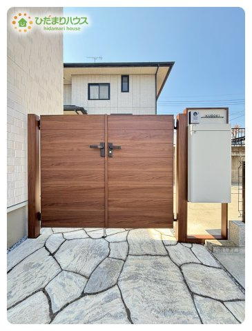熊谷市船木台1丁目　中古一戸建てのエントランス|木目調の門柱と石畳アプローチが上質な雰囲気を演出するエントランスです。住まいの第一印象を高め、来客を心地よく迎え入れます。外観との統一感も美しく、毎日の帰宅が楽しみになる洗練されたアプローチです。