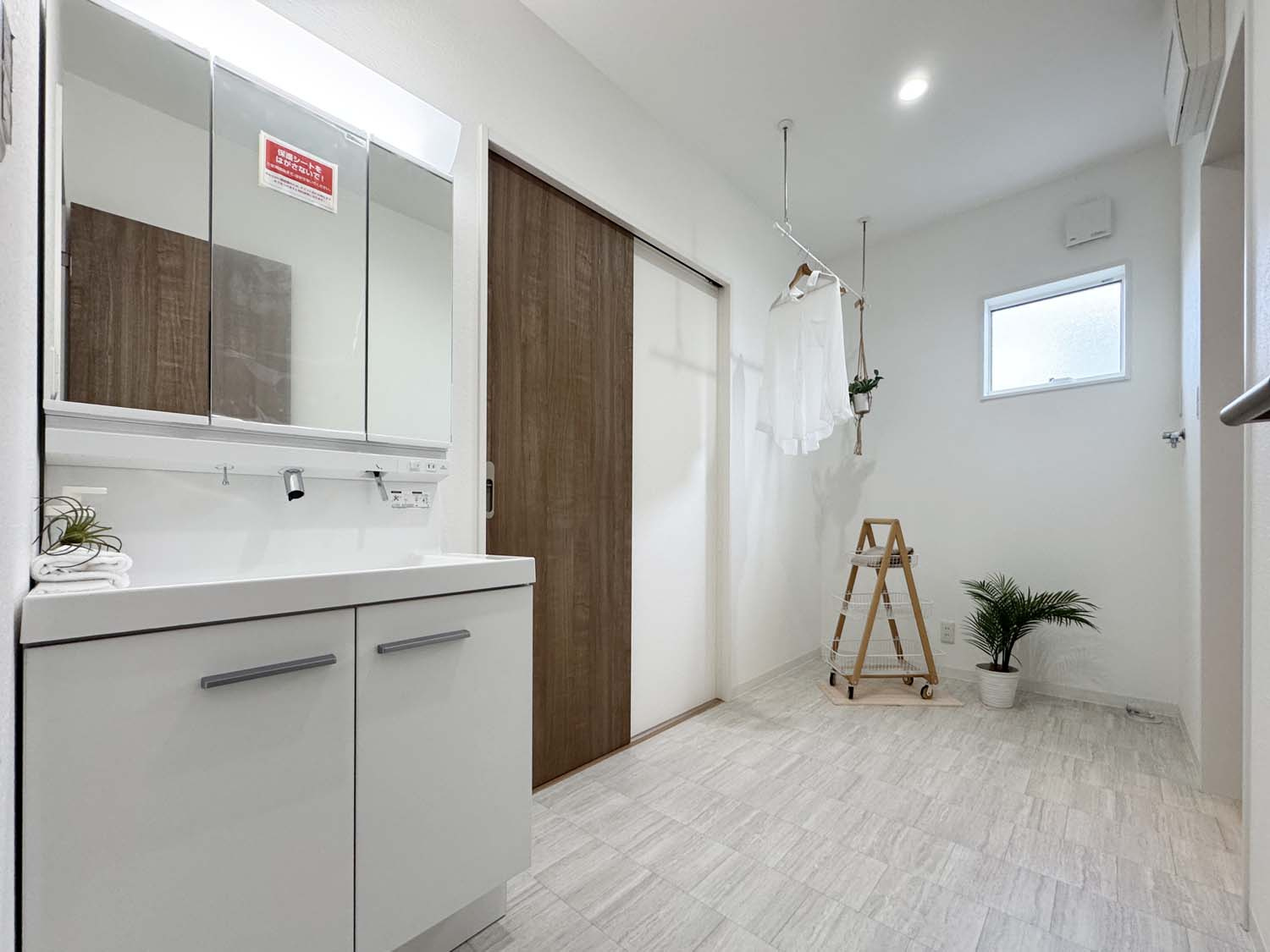 制震＆サンルームを備えた家事楽の家：松永町5丁目 限定1棟の独立洗面台|収納豊富な三面鏡、収納スペースを備えていますので、お洗濯、洗面、脱衣といったそれぞれのシーンで機能的にご利用頂けます。
キッチからランドリールームまでをむすぶ家事楽動線です！