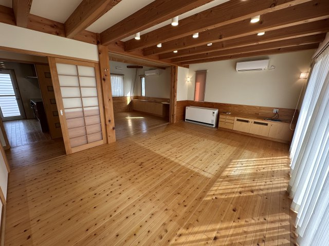 苫田郡鏡野町薪森原　中古住宅6DK+Sの居間・リビング|大きな窓のあるゆったりとしたリビングダイニング。造作家具もあり、テレビ台としても便利です。稼働間仕切りを開ければ、約20帖の空間が広がります。