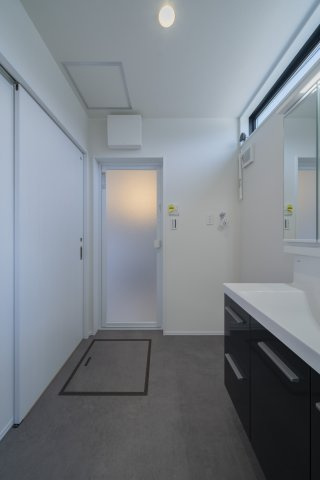 かすみケ丘東の洗面所|3面鏡付きの洗面化粧台で身支度がはかどり、そのまま主寝室へ移動できる便利な動線が魅力です。