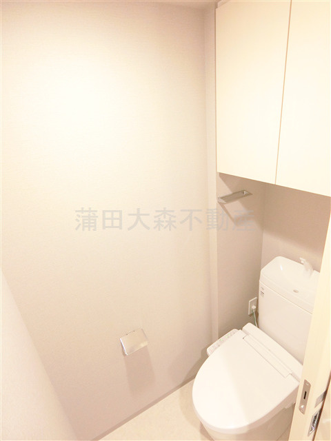 クレストコート池上のトイレ|吊戸棚とカウンター温水洗浄便座付きのトイレ　