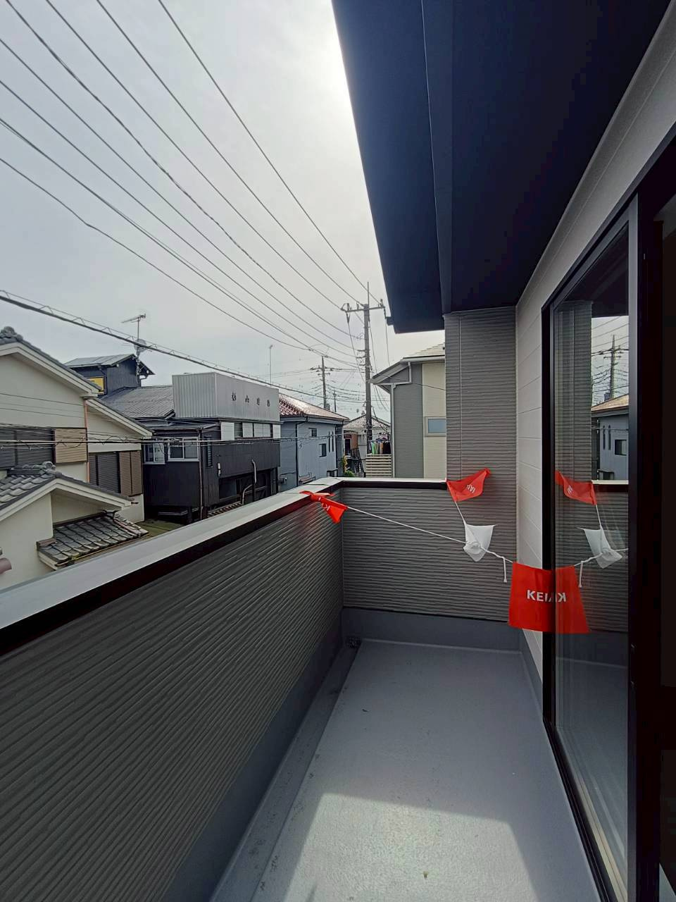 三郷市　後谷　新築戸建　全1棟の外観|屋根付きバルコニーを採用しており、急な雨でも洗濯物が濡れにくく、毎日のお洗濯に便利なスペースです。天候の変化を気にしすぎず使いやすく、家事負担の軽減にもつながります。