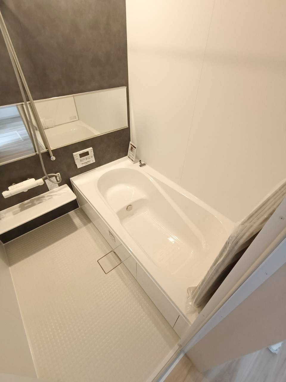 三郷市　後谷　新築戸建　全1棟の浴室|落ち着いたアクセントパネルが印象的な、清潔感のある浴室。ゆったりとした浴槽で、一日の疲れを癒すくつろぎの時間を過ごせます。浴室内はすっきりとしたつくりで、お手入れのしやすさも魅力。