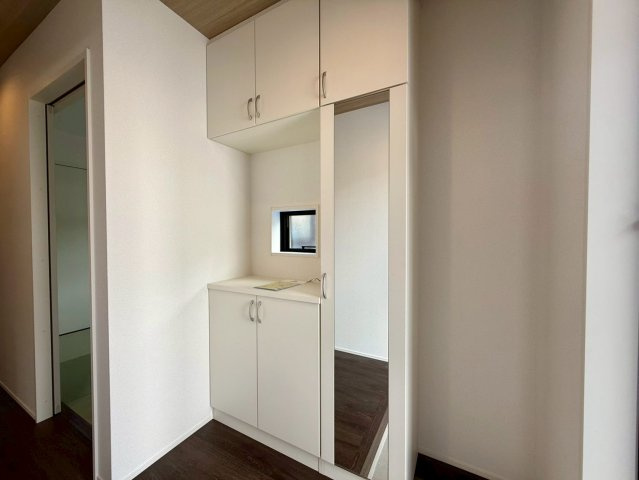 高知市朝倉丙4期2棟 1号棟の玄関|姿見裏の収納は高さがあり、ブーツや傘など長物もすっきり片付きます