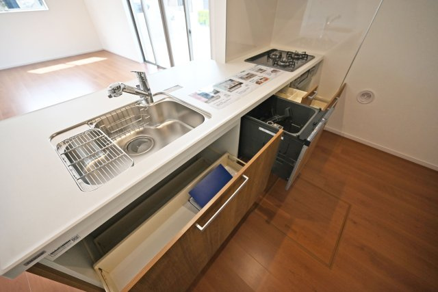 テラシエ水明台2丁目新築一戸建て│5LDK+駐車並列2台可のキッチン|キッチン天板下いっぱいに収納庫を設けてあります。シンクした収納庫にはナイフホルダーも標準搭載。食器洗い乾燥機や浄水器一体型水栓も標準仕様のユニットが導入されています。