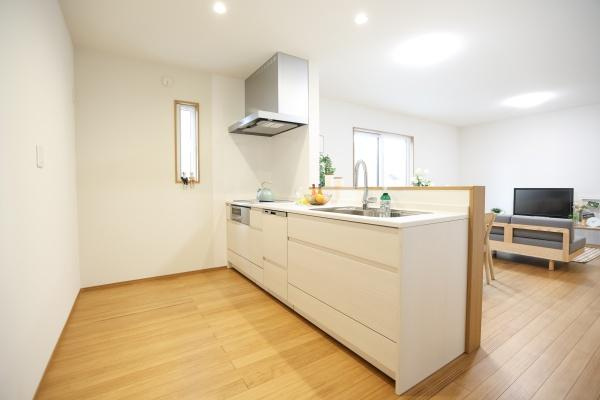 センチュリータウン関園ⅡNのキッチン|シンプルなデザインのキッチンは空間がすっきりとしています。窓から光が差し込み明るさが感じられます。木目調のフローリングと白いキッチンが調和しています。清潔感のある印象です。