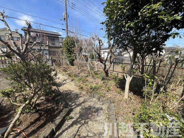 高台の眺望が魅力の山林つき中古戸建の庭|道路からのアプローチの両サイドに設けられたお庭