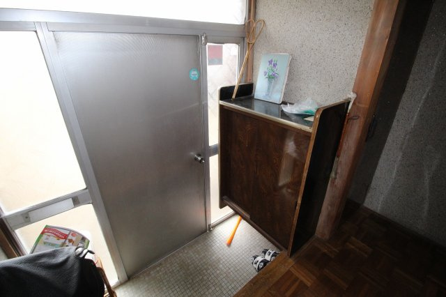 小山市羽川の玄関|レトロなタイル調の下駄箱が目を引く玄関スペース。コンパクトながらも使い勝手がよく、来客時にもすっきりと迎えられる空間です。すりガラスからやわらかい光が入り、明るさも確保されています。