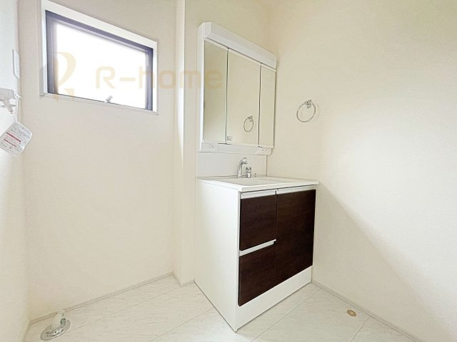 笠間市笠間第10　新築戸建て　4号棟の洗面所|三面鏡にハンドシャワー付きの使いやすい洗面台です。忙しい朝も家族みんなで身支度可能なスペース。