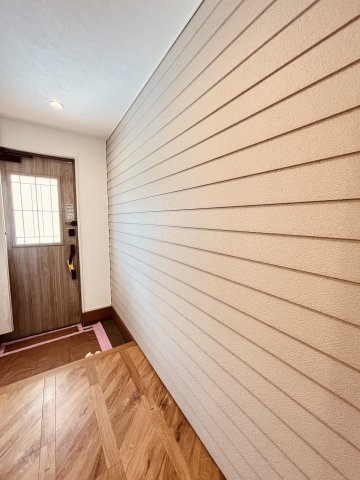 海と空と家族と。片瀬海岸でゆとりある暮らし。の玄関|「玄関を開けた瞬間、センスが伝わる。」
木目調サイディングが印象的な玄関ホール。
帰宅したとき、ふっと気持ちが落ち着くような、やさしい素材感です。